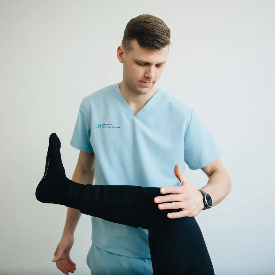 Daan Verhoef, eigenaar van Fysio Eemkade, behandelt een knie