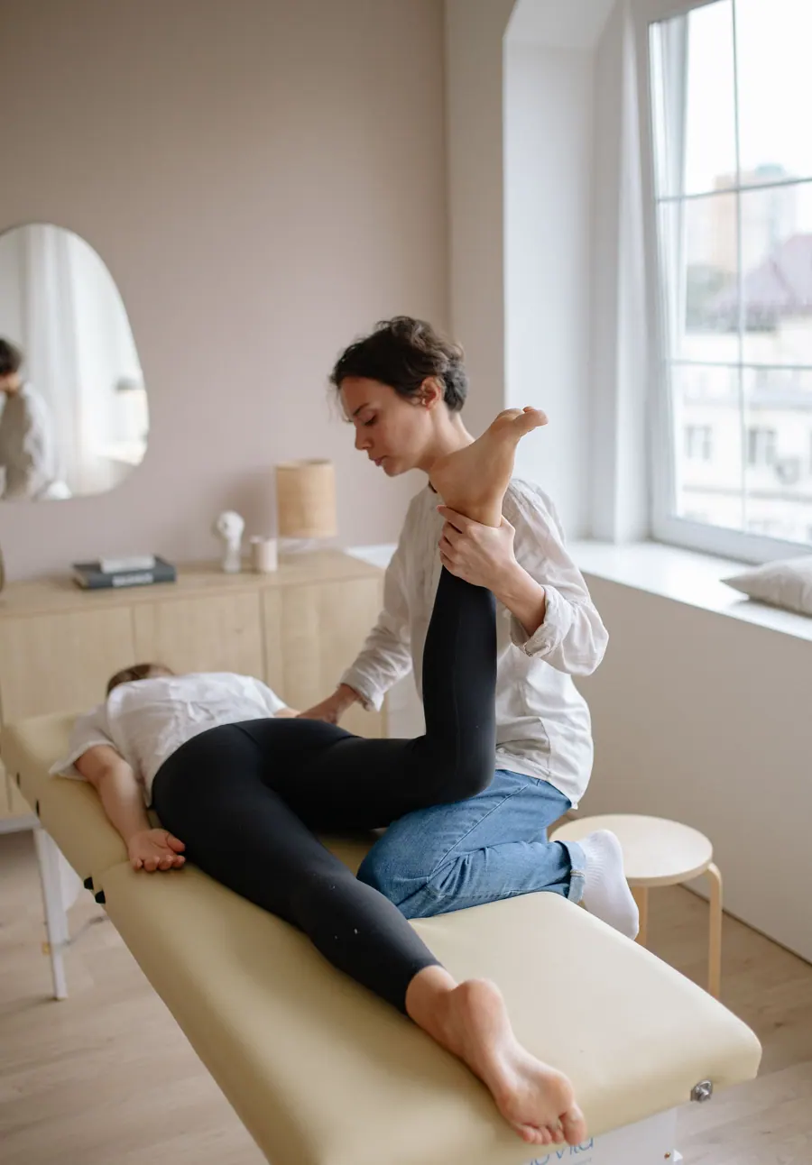Noor beweegt het been van een patiënt die op de bank ligt
