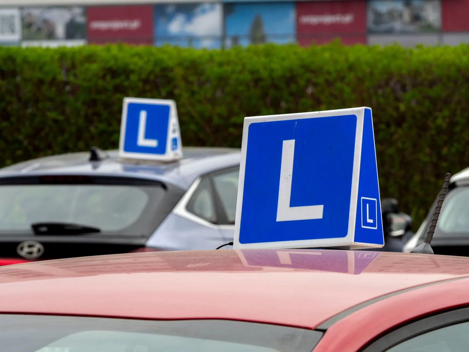 Blauwe L-borden op het dak van lesauto’s