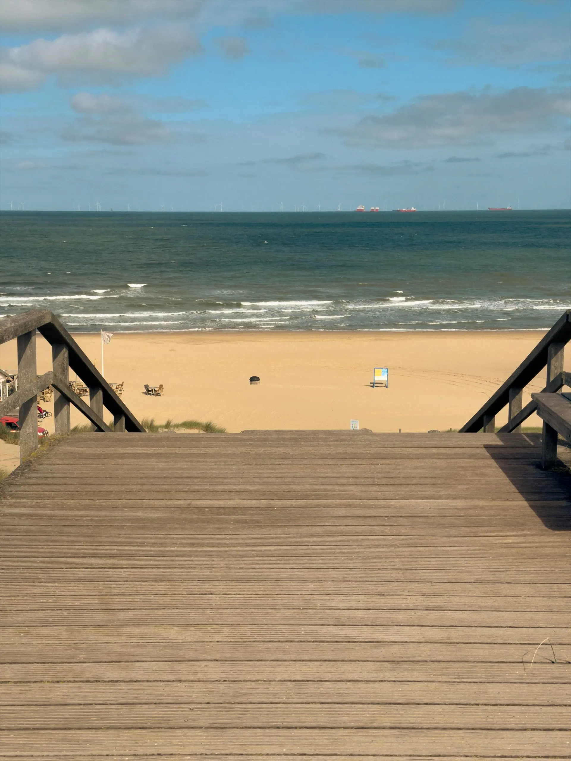 Een houten trap over het duin naar het strand en de zee