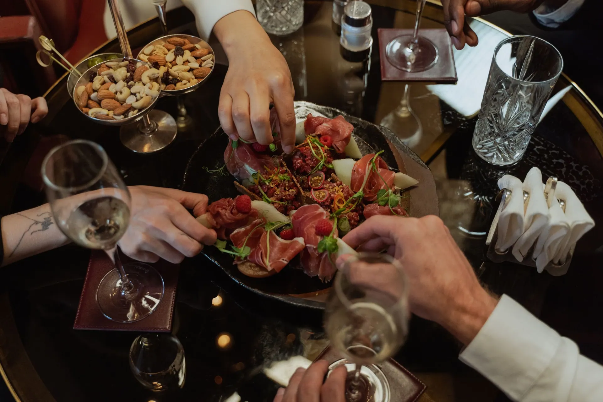 Handen die reiken naar gerechten op tafel